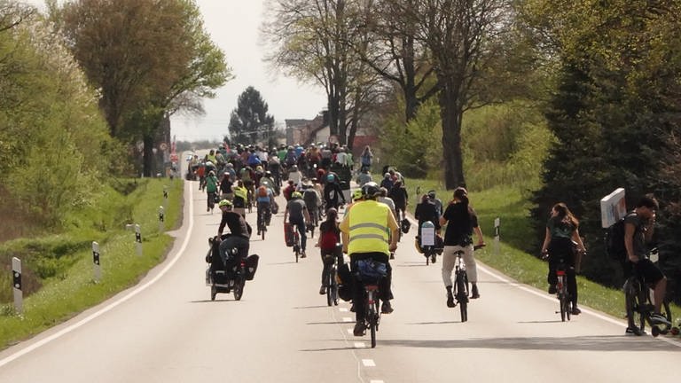 Eine große Gruppe von Radfahrenden belegt beide Spuren einer zweispurigen Straße (Foto: SWR, Harry Röhrle)