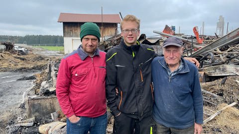 Martin Benzing, David Benzing und Fritz Benzing stehen vor den Trümmern, die einst der familieneigene Bauernhof waren