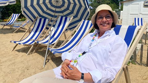 Annette Stiehle sitzt in einem Liegstuhl mit blau, weiß gestreiftem Stoff. Bei der Gartenschau in Balingen wurde zur Halbzeit der 200.000. Besucher begrüßt  (Foto: SWR, Bertram Schwarz)