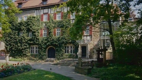 Ein parkähnlicher Garten mit einem efeubewachsenen Fachwerkgebäude im Hintergrund (Foto: Pressestelle, Stadt Reutlingen)