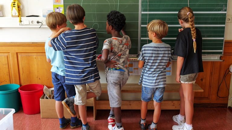 Kinder stehen in der Hector Kinderakademie an der Tafel. (Foto: SWR)