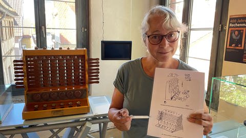 Karin Pfeffer mit Schickards Skizze, hinten der Nachbau von Schickards Maschine (Foto: SWR, Peter Binder)