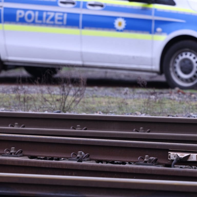 Ein Polizeiauto hinter Bahngleisen