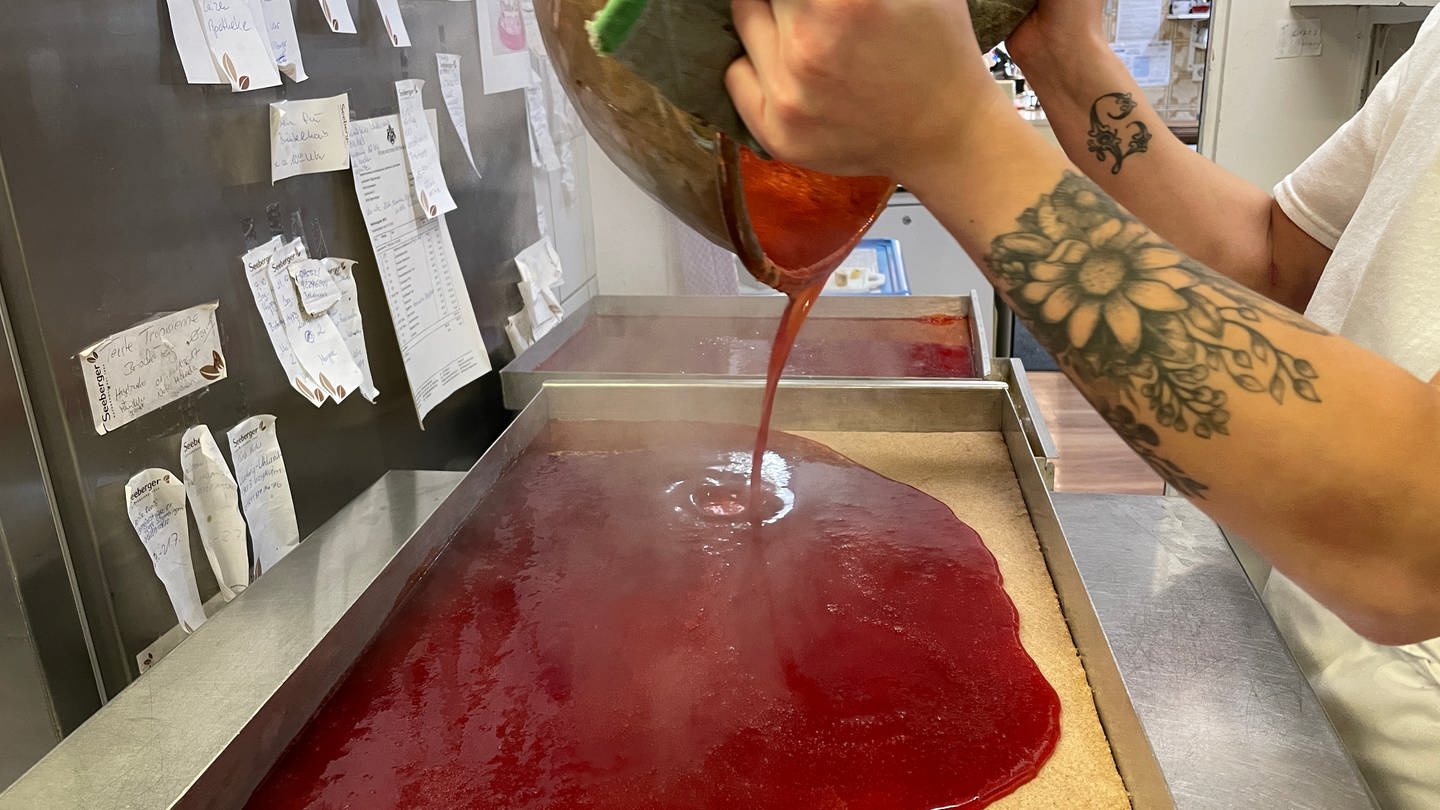 Herstellung der Fruchtfüllung für Dominosteine: Die rote Fruchtsoße - hier Erdbeere - kommt auf ein Blech und wird dann beim Trocknen fest. (Foto: SWR, Andrea Schuster)