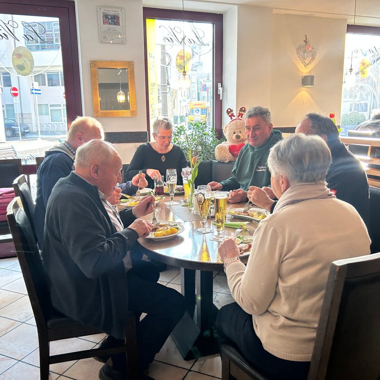 Man sieht einen runden Tisch mit zwei Frauen und vier Männern. Sie essen in einem Restaurant. Auf dem Tisch steht Essen und Trinken. (Foto: SWR)