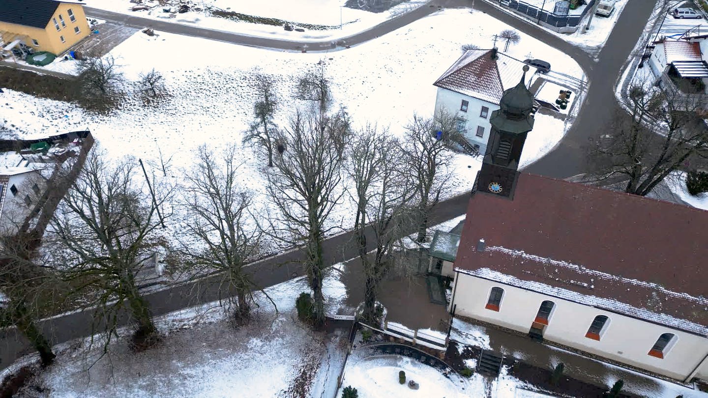 Die Kirche in Hausen am Tann ist umgeben von Bäumen. Drei davon sollen nun entfernt werden, wogegen Baumretterin Christa Bruder kämpft. (Foto: SWR)