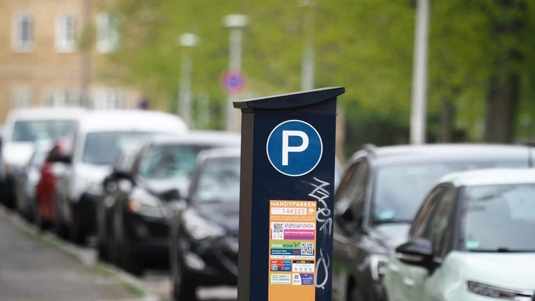 Ein Parkscheinautomat ist vor einer Reihe geparkter Autos zu sehen. Eine Online-Petition will Parkgebühren für Kita-Mitarbeiter abschaffen. (Foto: dpa Bildfunk, Picture Alliance)