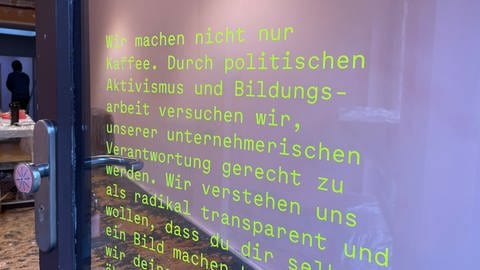 Auf einer Glastür der Kaffeerösterei SUEDHANG in Tübingen steht geschrieben, dass sie als Café nicht nur Kaffee machen, sondern auch politisch aktiv sein wollen. Nach einer Anti-Rechtsextremismus-Aktion hat das Team jetzt Drohungen bekommen.