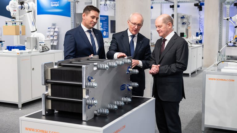 Andreas Beutel (links) und Kurt Schmalz, beide Geschäftsführer der J. Schmalz GmbH, führen Bundeskanzler Olaf Scholz (SPD) bei seinem Besuch beim Vakuumtechnik-Unternehmen J. Schmalz herum.