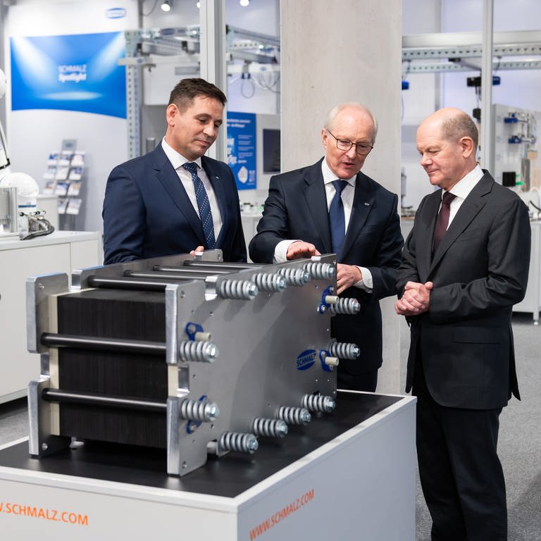 Andreas Beutel (links) und Kurt Schmalz, beide Geschäftsführer der J. Schmalz GmbH, führen Bundeskanzler Olaf Scholz (SPD) bei seinem Besuch beim Vakuumtechnik-Unternehmen J. Schmalz herum.
