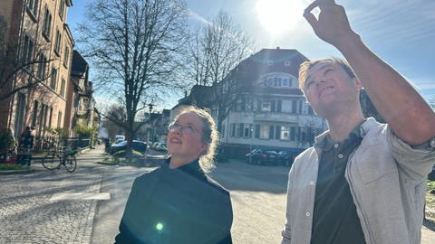 Sie wollen, dass in Tübingen weniger bezahlbarer Wohnraum verschwindet: Annette Guthy und Markus Buckenmayer von GIMA. Sie blicken auf dem Bild auf ein Haus in der Südstadt, das teuer verkauft wurde.