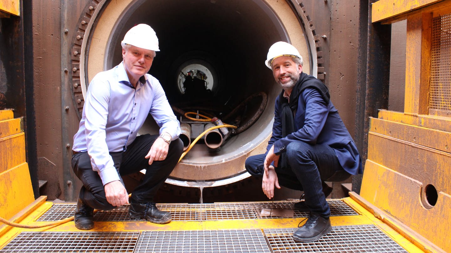 Oberbürgermeister Boris Palmer und swt-Geschäftsführer Ortwin Wiebecke in der Baugrube am Tunneleingang. Tübingen will 2030 klimaneutral sein und baut deshalb sein Fernwärmenetz aus. (Foto: Stadtwerke Tübingen)