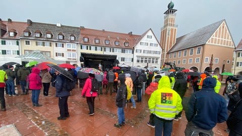 Im Hintergrund das Rathaus von Freudenstadt, schräg davor eine Bühne, im Vordergrund Demonstrierende in Regenkleidung.  (Foto: SWR, Schwarz)