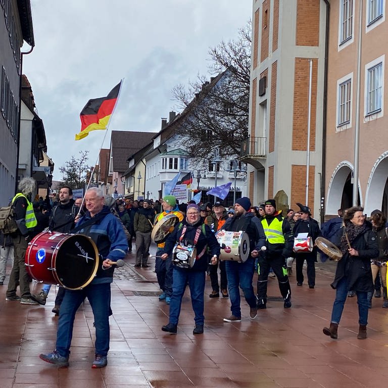 Zahlreiche Personen mit Trommeln, Fahnen und Tröten in der Fußgängerzone von Freudenstadt