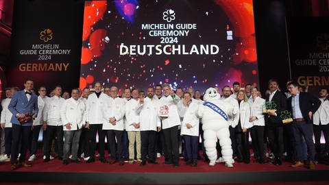 Die Preisträger und Preisträgerinnen stehen nach der Verleihung der Michelin-Sterne 2024 für deutsche Restaurants in der Handelskammer Hamburg auf der Bühne.