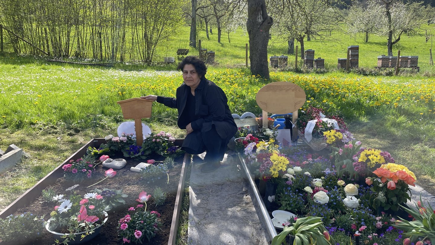 Meryem Üge-Evren kniet neben dem Grab ihres Mannes auf dem Friedhof in Nagold (Foto: SWR, Mia Zundel)