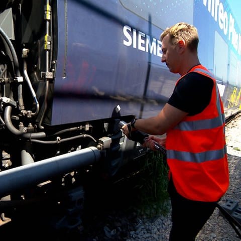 Ein Mitarbeiter betankt einen der Wasserstoffzüge der Deutschen Bahn. Die Tankstelle gehört zum Kraftwerk am Hauptbahnhof in Tübingen