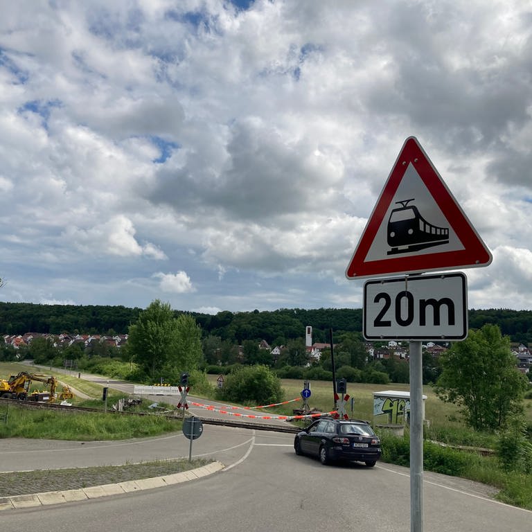 Der bei einem Zugunglück stark beschädigte Bahnübergang in Blaustein-Arnegg (Alb-Donau-Kreis) wird vom Sicherungspersonal der Bahn (im schwarzen Wagen) überwacht, bis neue Schranken eingebaut sind. (Foto: SWR, Monika Götz)
