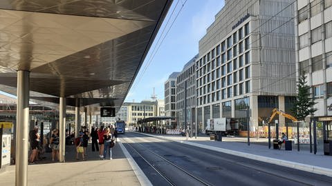 Die Straßenbahnlinie vor dem Ulmer Hauptbahnhof. Pendlerinnen und Pendler warten auf Bus und Straßenbahn. (Foto: SWR, Torsten Blümke)