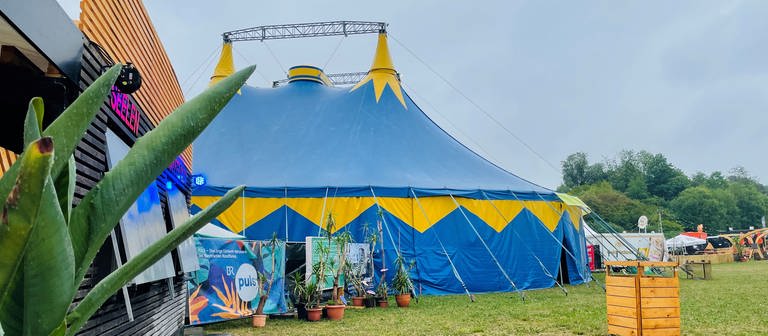 Grauer Himmel, buntes Zelt: Hier steht eine der drei Bühnen für das Obstwiesenfestival in Dornstadt, auf denen Freitag und Samstag viel Musik gespielt wird. (Foto: SWR)