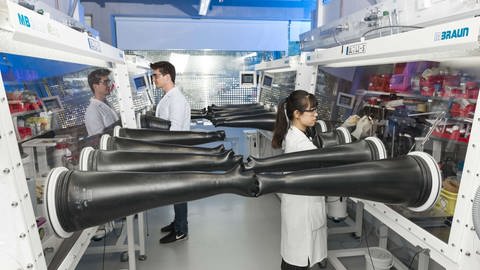 Aufbauten in einem Labor mit Forscherinnen und Forscherin. Im Helmholtz-Institut in Ulm wird nach Alternativen für Lithium-Ionen-Batterien gesucht.  (Foto: Pressestelle, Helmholtz-Institut Ulm)