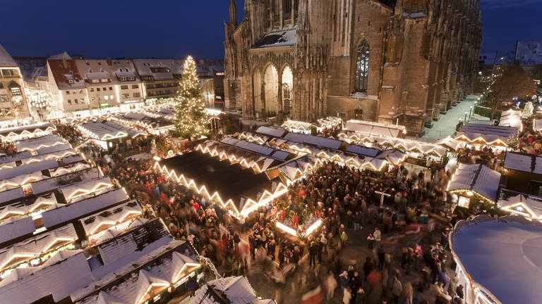 Schneebedeckte Buden auf dem Weihnachtsmarkt in Ulm auf dem Münsterplatz: Die Händler sind mit dem Geschäft zufrieden. (Foto: IMAGO, IMAGO Westend61)