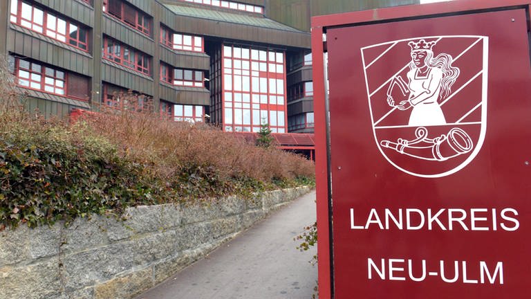 Gebäude (Landratsamt Neu-Ulm), davor ein rotes Schild "Landkreis Neu-Ulm" (Foto: SWR)