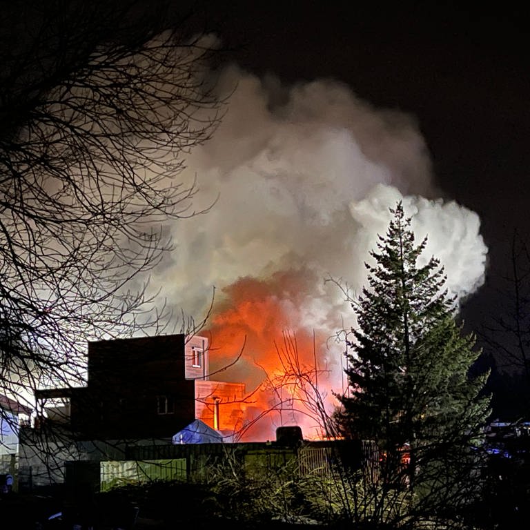 Qualm und Feuerschein eines brennenden Gebäudes. Der bei einem Brand in einem Dachdeckerbetrieb in Laichingen (Alb-Donau-Kreis) entstandende Qualm war weithin zu sehen.  (Foto: z-media, Ralf Zwiebler)