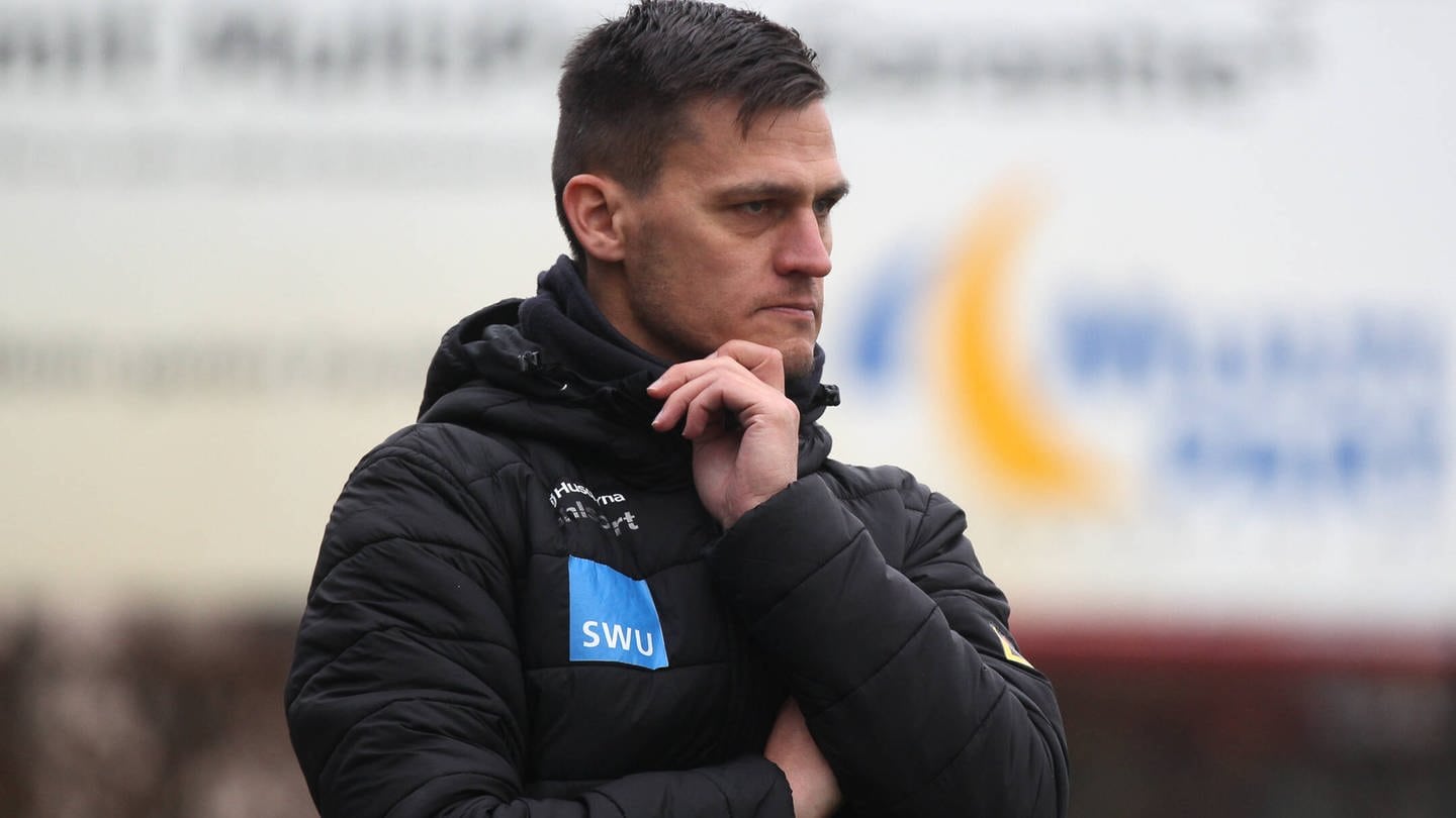Ein Mann schaut nachdenklich vor sich hin. Ulms Trainer Thomas Wörle sieht in Gegner Hoffenheim 