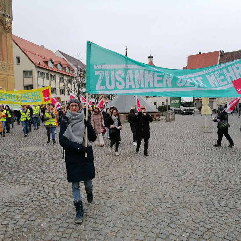 Ein Demonstrationszug mit Plakaten - Verd.i-Warnstreik: Beschäftigte städtischer Kindertagesstätten ziehen am Mittwoch in einem Demonstrationszug durch die Innenstadt von Ulm.  (Foto: SWR, Hannah Anhorn)