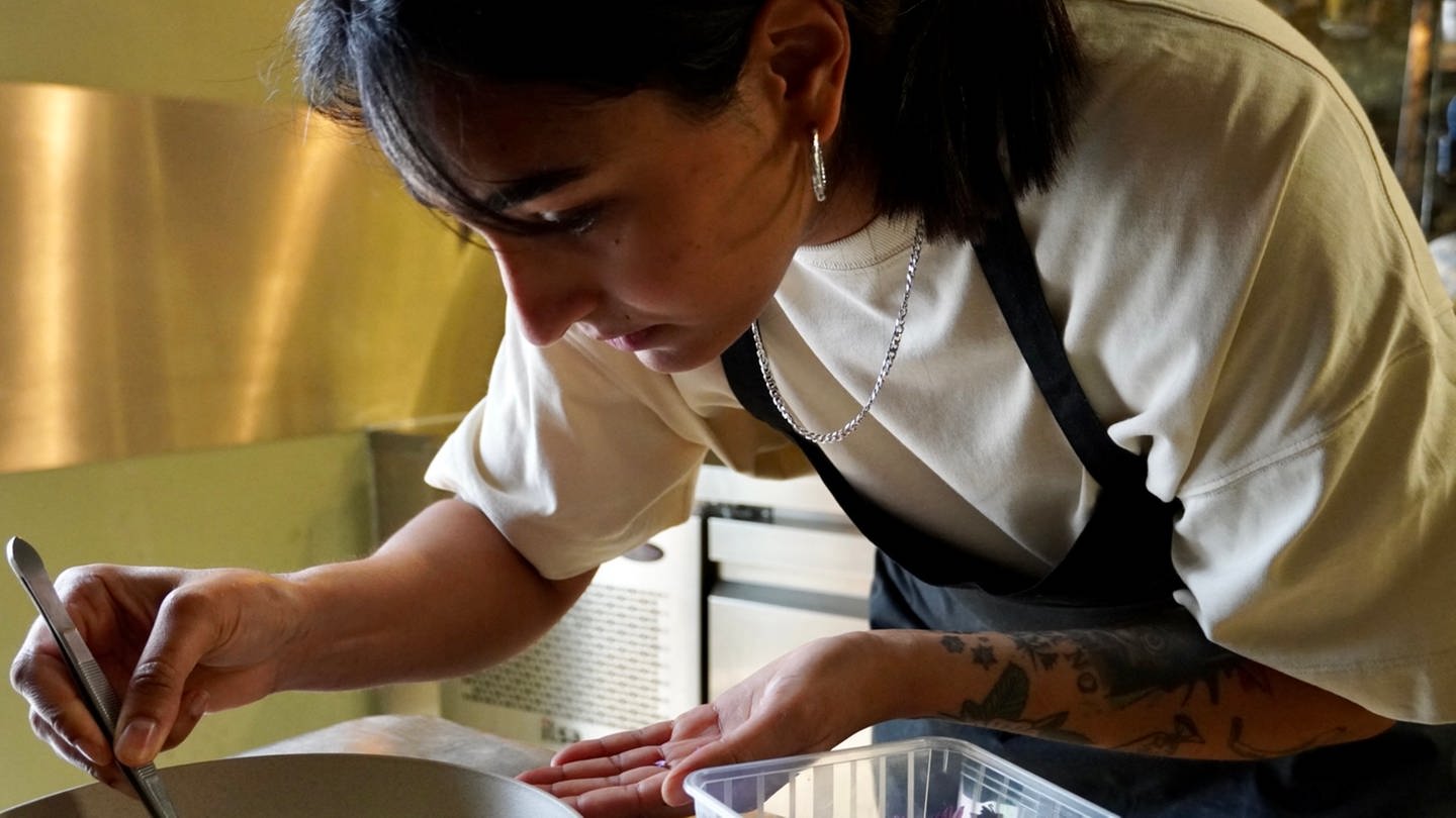 Köchin Alina Meissner-Bebrout dekoriert einen Vorspeisen-Teller in ihrem Lokal, für das sie mit einen Michelin-Stern ausgezeichnet wurde. (Foto: SWR, Hannah Schulze)