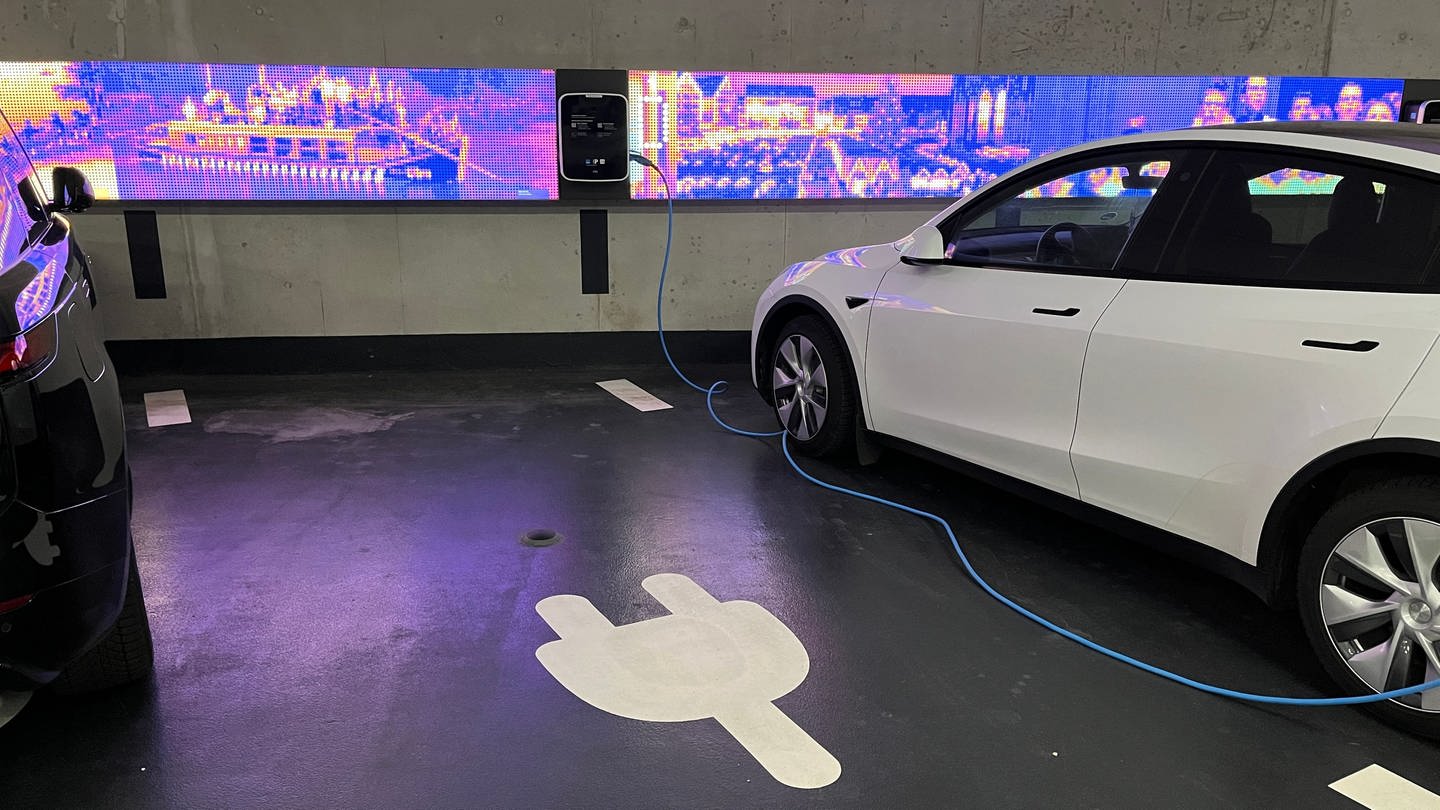 Ein Auto steht in einem Parkhaus an einer E-Ladesäule. Im Boden ist ein Sensor verbaut, der misst ob der Parkplatz belegt ist. Er ist Teil der Smart City Projekte der Stadt Ulm. (Foto: SWR, Markus Bayha)