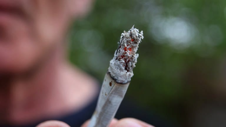 Ein Mann hält einen Joint. Ab dem 1. April ist durch das Cannabis-Gesetz der Konsum der Droge teilweise erlaubt. (Foto: dpa Bildfunk, picture alliance/dpa | Karl-Josef Hildenbrand)
