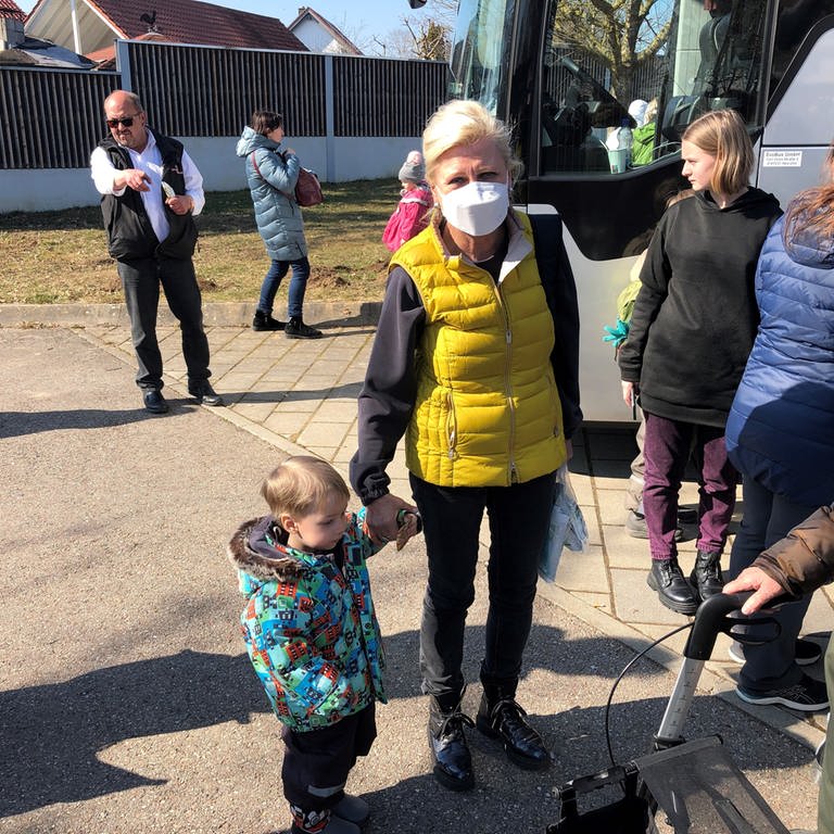 Eine Frau steht mit einem Kleinkind vor einem Bus - sie sind als Flüchtlinge aus der Ukraine in Elchingen angekommen (Foto: SWR, Frank Polifke)