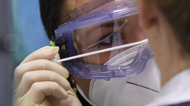 Ärztin mit Schutzbrille und Schutzmaske testet auf Corona (Foto: dpa Bildfunk, picture alliance Robert Michael dpa)