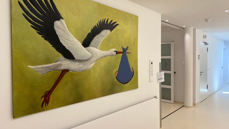 Ein Gemälde von einem Storch mit einem Baby. (Foto: SWR)