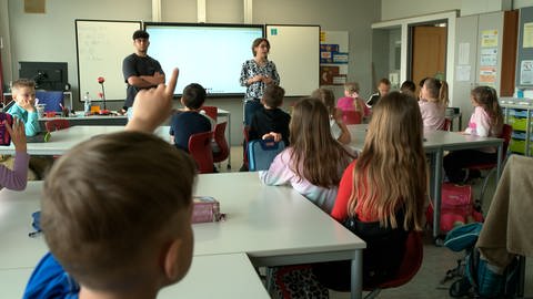 Schülerinnen und Schüler im Klassenzimmer. Pedram Farsi und Deutschlehrerin Christiane Markert in der zweiten Klasse der Schwarzfeldschule Aalen-Dewangen. (Foto: SWR, Philipp Oswald)