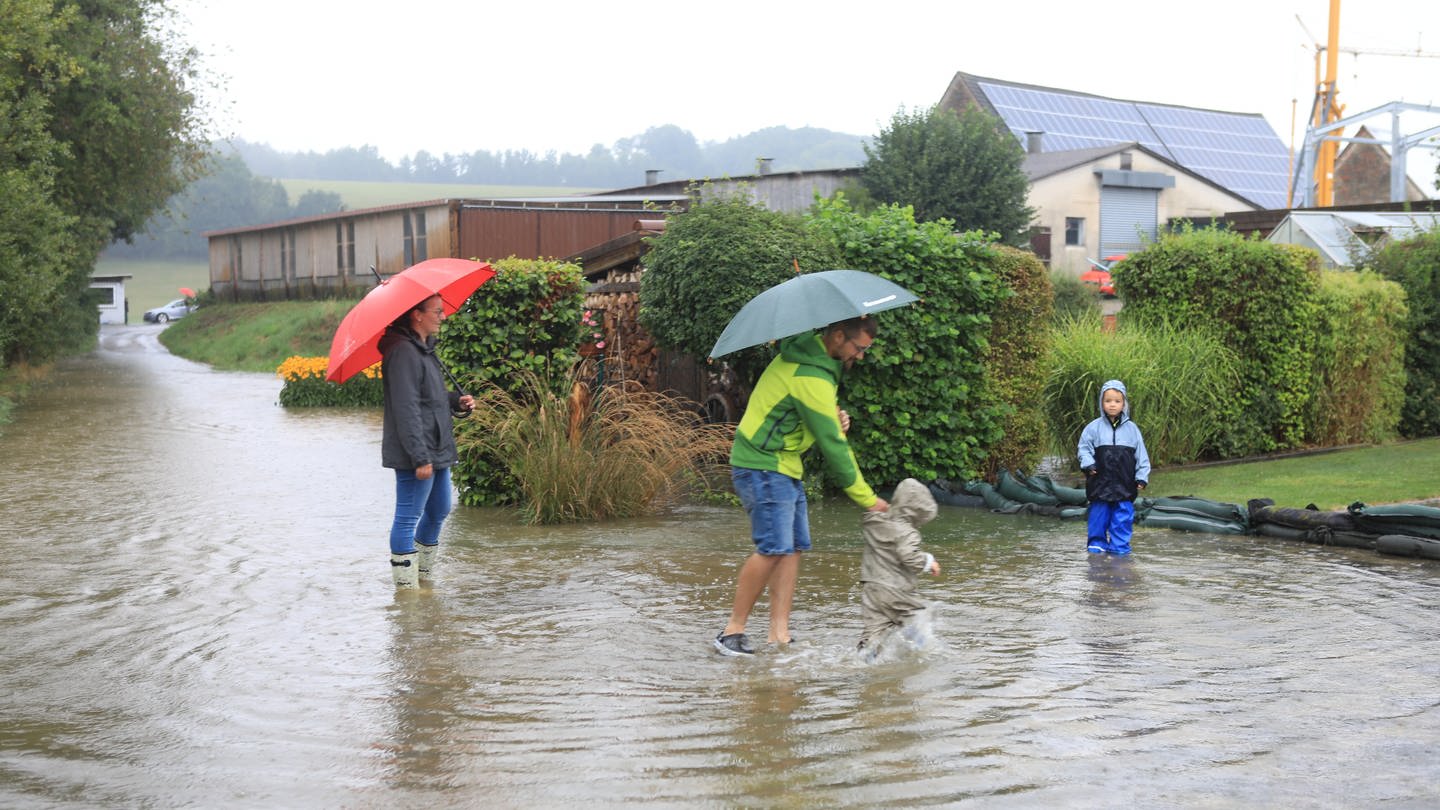 Kinder plantschen in einer riesigen Pfütze. Hochwasser nach Starkregen im Alb-Donau-Kreis in Schnürpflingen und Staig (Foto: Ralf Zwiebler)