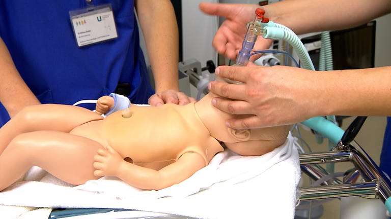 Eine Baby-Puppe liegt auf einem speziellen Früchchen-Tisch. Frühgeborene Kinder brauchen oft Sauerstoff, weil sie noch nicht selbständig atmen. (Foto: SWR)