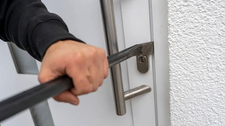 Eine Brechstange wird an eine Haustüre angelegt. Die Kriminalpolizei Ulm hat eine Einbruchserie aufklären können. (Symbolbild) (Foto: IMAGO, IMAGO / MiS)