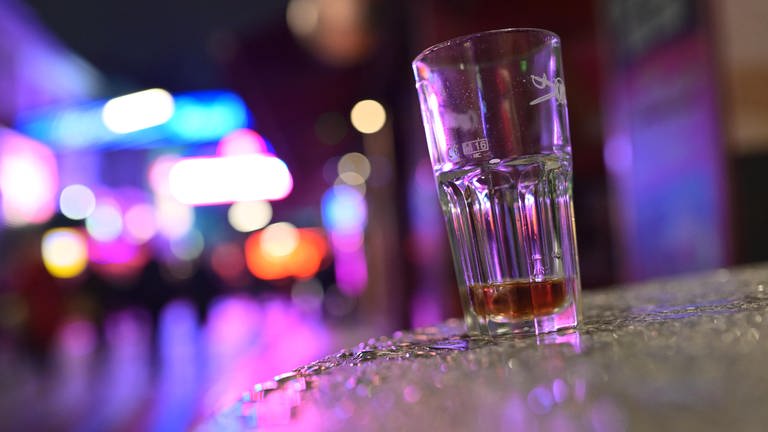 Ein fast leeres Glas auf einem Tisch: Alkohol gehört für viele zur Fasnet oder zum Fasching dazu. Was gegen Kater wirklich hilft (Foto: dpa Bildfunk, picture alliance/dpa | Jonas Walzberg)