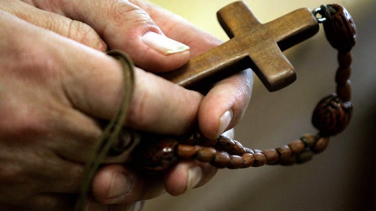 Ein Rosenkranz in der Hand - das Verfahren gegen einen  Pfarrer in Ellwangen wegen Missbrauchsvorwürfen wurde eingestellt. (Foto: dpa Bildfunk, Matthias Schrader)