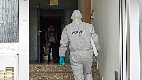 Ermittler in weißer Schutzkleidung betreten ein Treppenhaus. In Heidenheim ist am Dienstag eine Leiche in einer Wohnung entdeckt worden. Die Polizei ermittelt. (Foto: Markus Brandhuber)