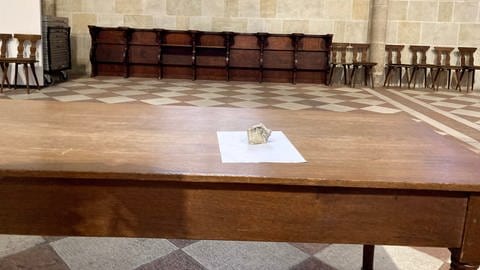 Ein Stück Putz liegt auf einem Tisch im Ulmer Münster. Dieses 120 Gramm schwere Stück ist von der Münsterdecke gestürzt.  (Foto: SWR, Anja Müller )