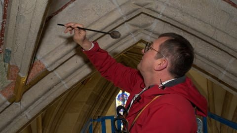 Restaurator Wolfgang Domes untersucht die Decke der Seitenschiffe im Ulmer Münster auf hohle Stellen. (Foto: SWR)