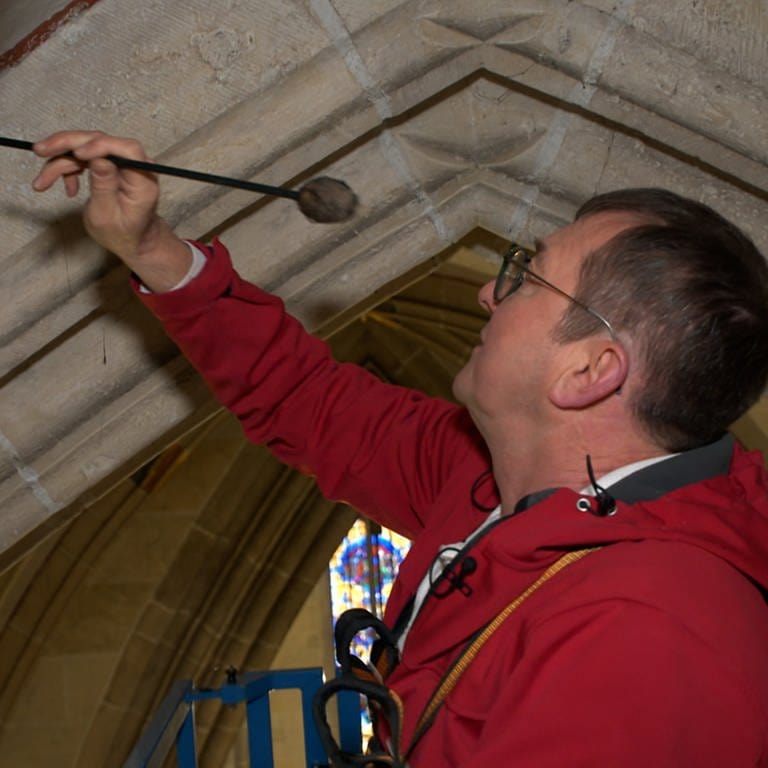 Restaurator Wolfgang Domes untersucht die Decke der Seitenschiffe im Ulmer Münster auf hohle Stellen.