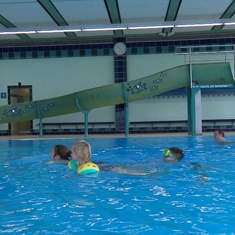 Eine Familie schwimmt im großen Becken des Hallenbads in Oberkochen, dass gerade wieder aufgemacht hat. 