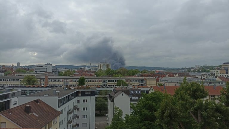 Ersten Angaben zufolge ist am Freitagabend ein Feuer in einem Elektronikfachmarkt in der Blaubeurer Straße in Ulm ausgebrochen. Über Ulm war eine dunkle Rauchwolke sichtbar.
