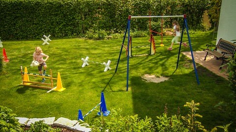 Ein Mädchen im Garten übt mit seinem Steckenpferd und "reitet" einen Parcour auf der grünen Wiese in einem Garten in Erbach ab. Durch das Rennen ist sie unscharf hinter einem Schaukelgestell zu sehen. Sie rennta auf ein Hindernis fürs Hobby-Horsing zu. (Foto: SWR)