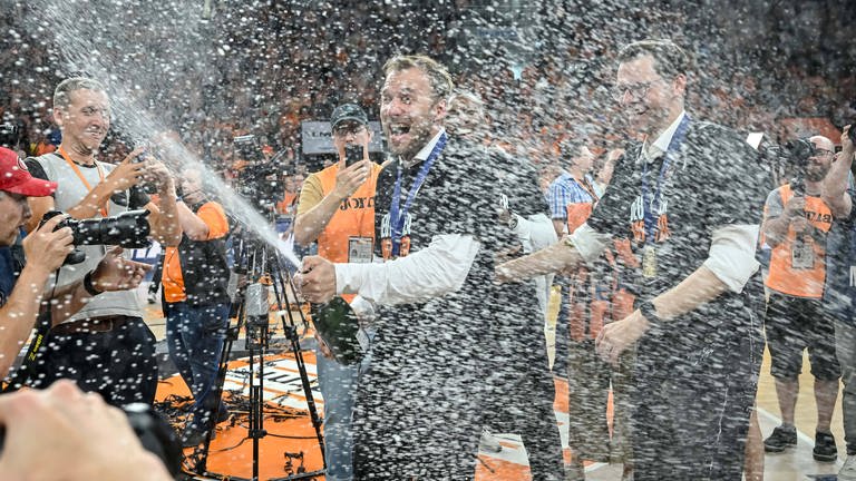 Headcoach Anton Gavel lässt die Korken knallen. Die Champagnerdusche erfasst auch Sportdirektor Thorsten Leibenath. (Foto: IMAGO, IMAGO | Langer)